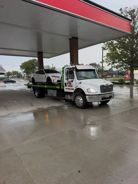 PS Towing truck working a roadside call on a rainy day